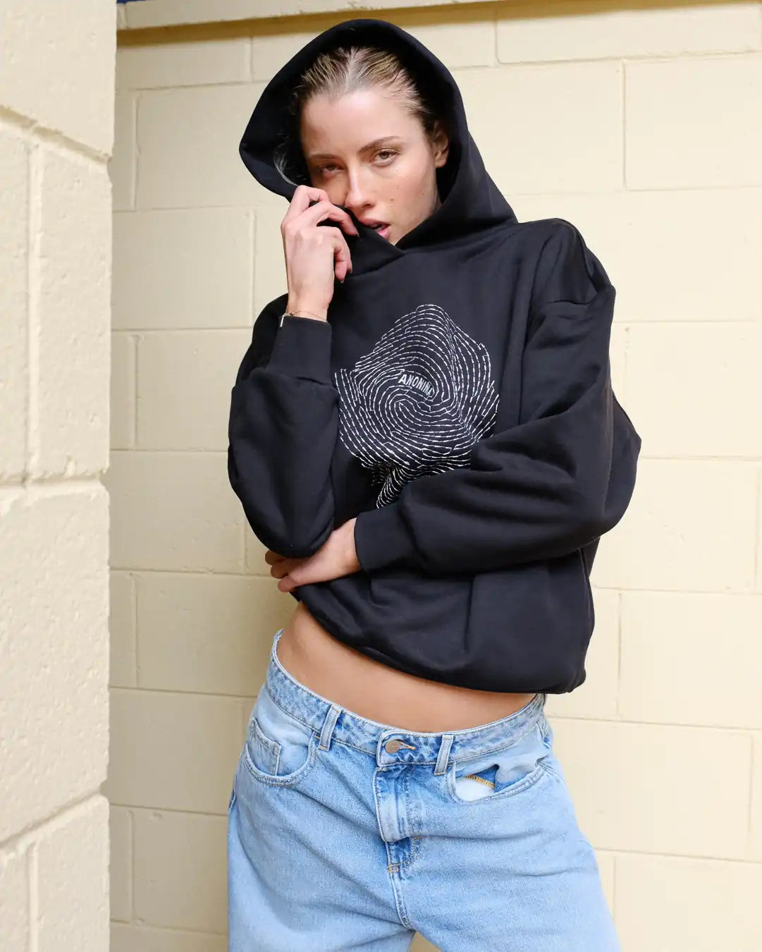 Woman wearing Societa Anonima hoodie in black with fingerprint embroidery on the front
